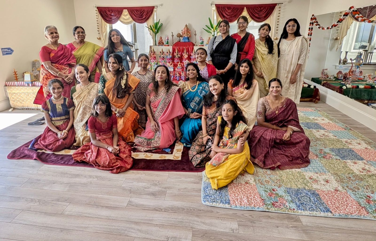 Students, teachers and families gathered in front of a golu display